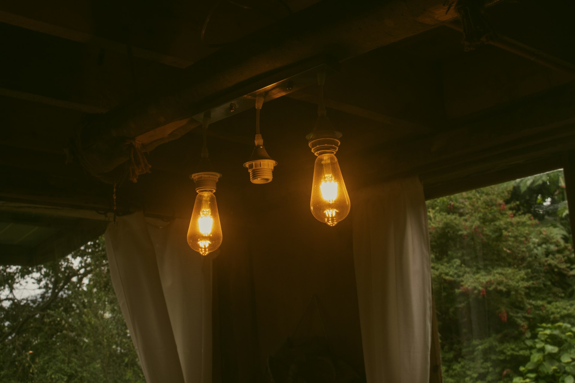 Three light bulbs are hanging from a ceiling